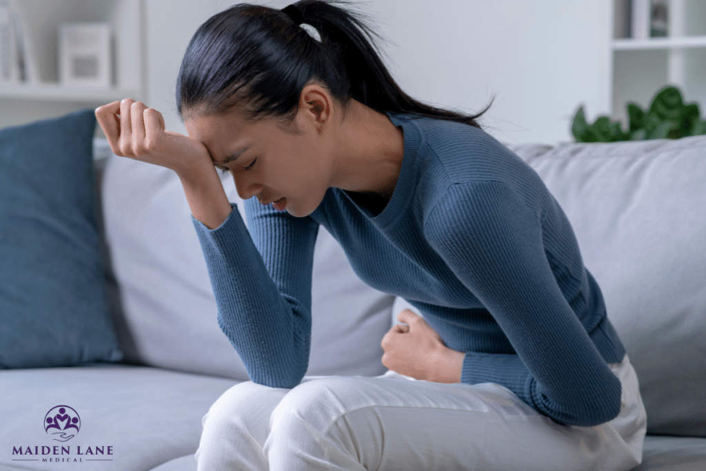 A woman resting her head on her hand is feeling pelvic pain that disrupts her daily life in New York, Manhattan.