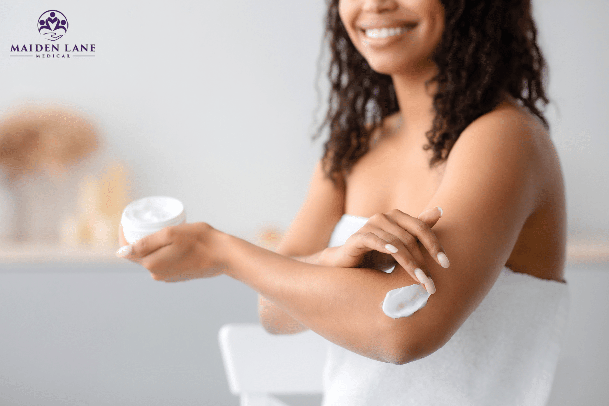 A woman applying lotion to her body after taking a shower in Manhattan, New York.
