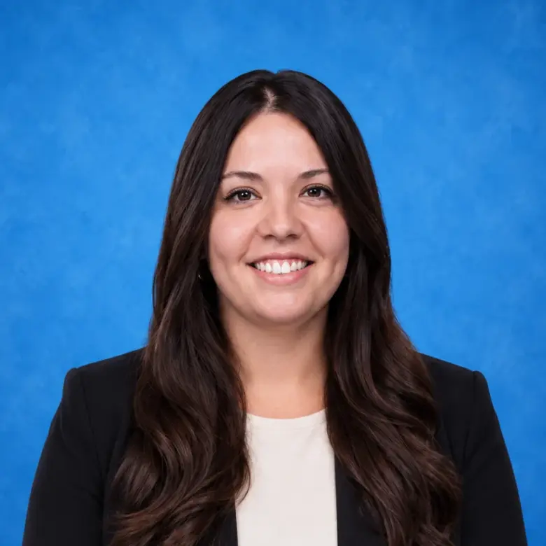 Headshot of Julia Hernandez, MD, smiling in front of a blue background.