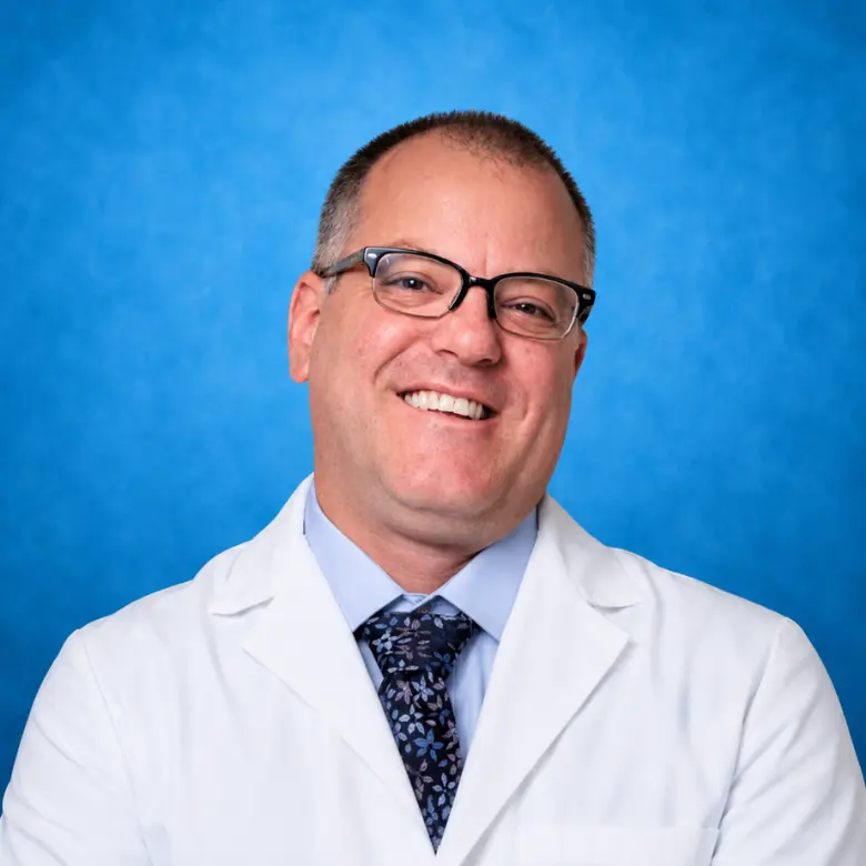 Headshot of Kenneth A. Levey, MD MPH FACOG FACS with blue background