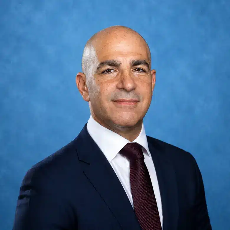 Headshot of Ron Bakal, MD with blue background