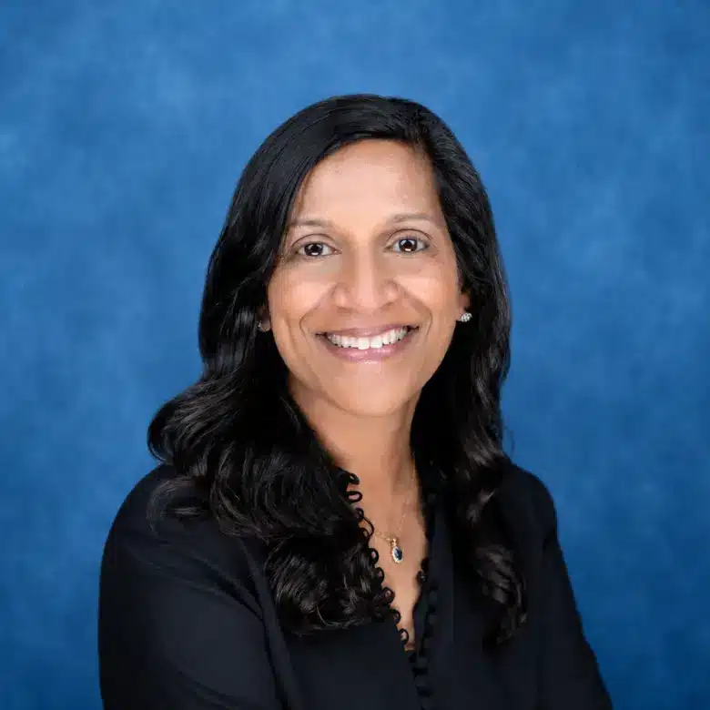 Headshot of Sarah Chacko, MD with blue background