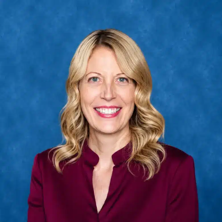 Headshot of Dr. Stacy Henigsman, DO with blue background