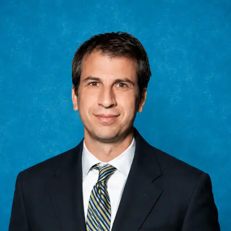 Headshot of Tal Oren, MD, PhD with blue background